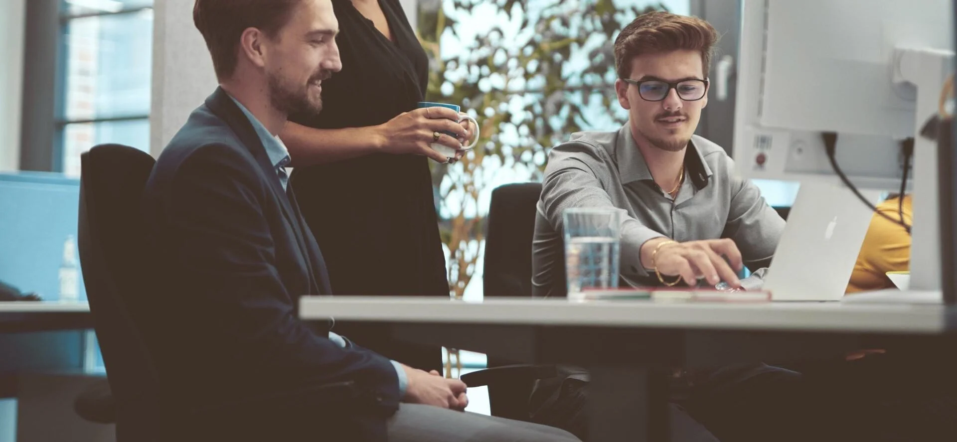 Three people in an office looking at a computer