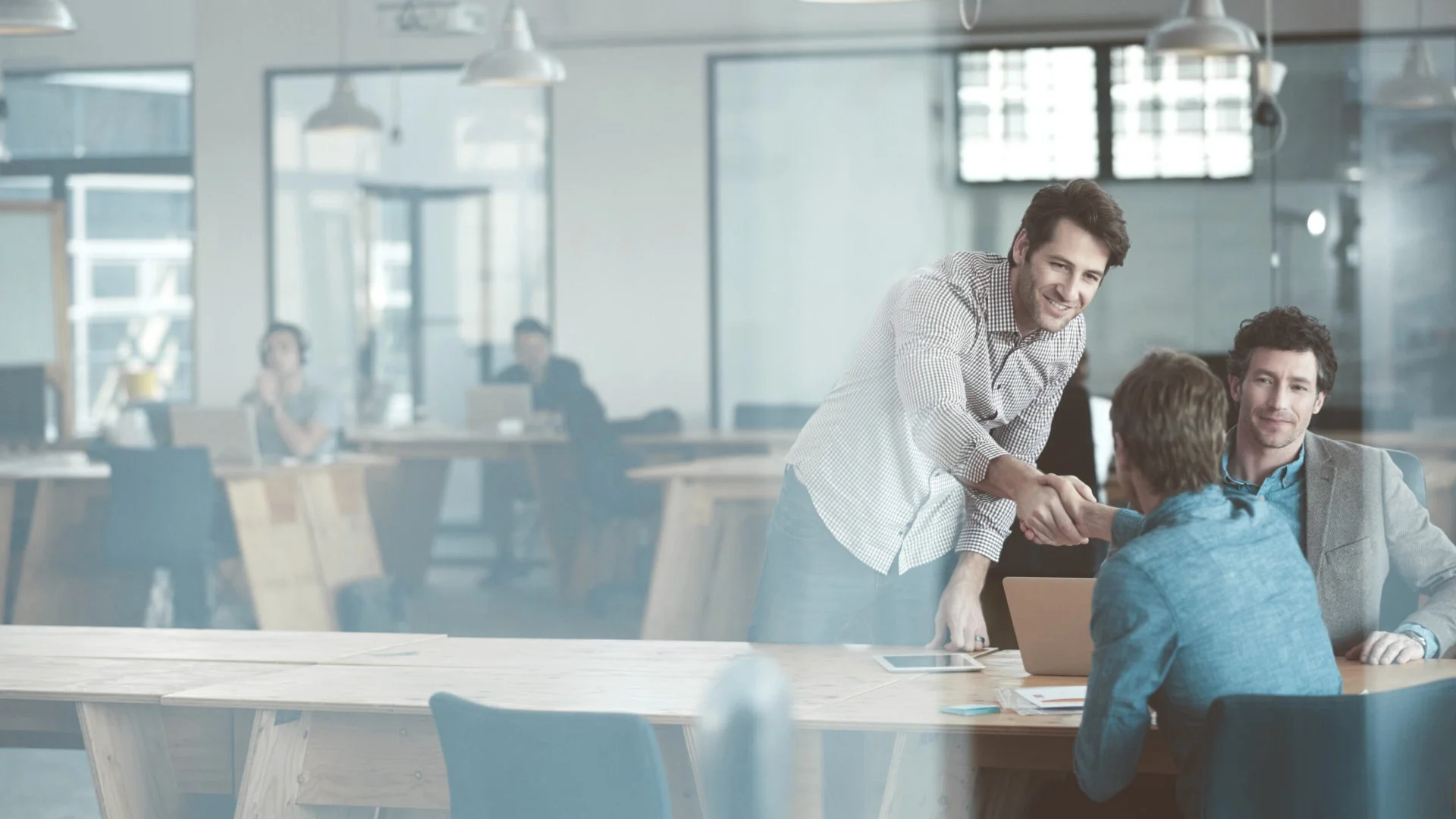 People in an office through a glass door