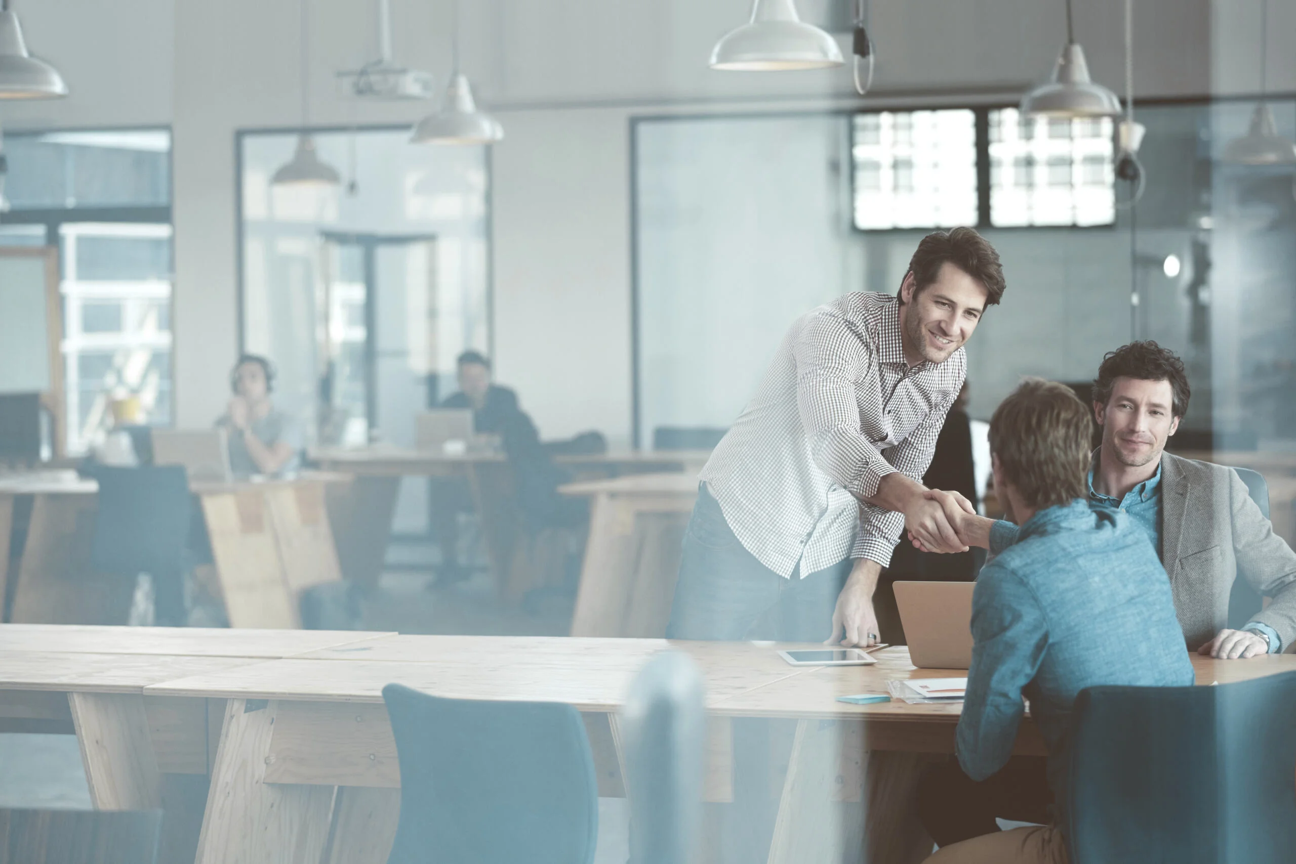 People in an office through a glass door