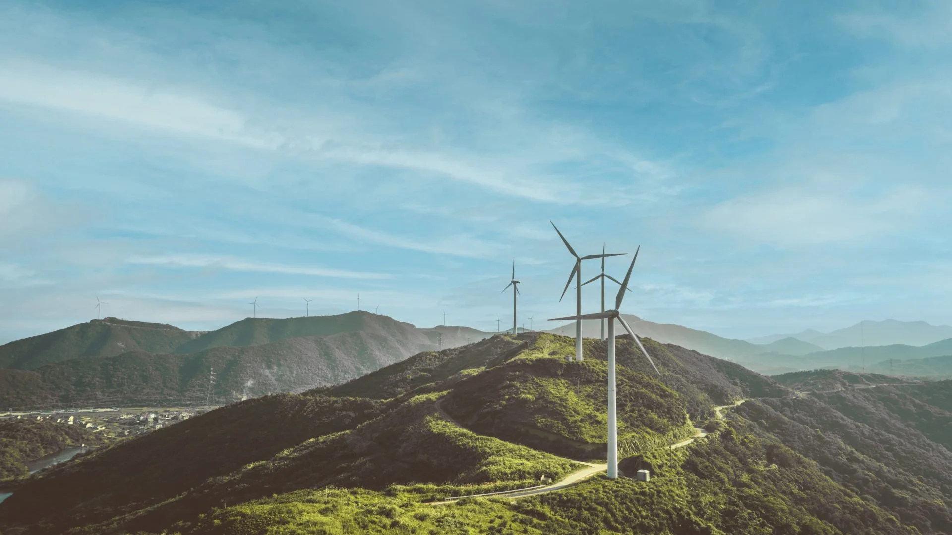 View of green landscape with wind turbines
