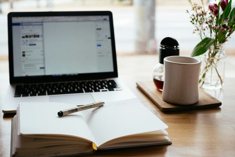 Notepad with laptop in background